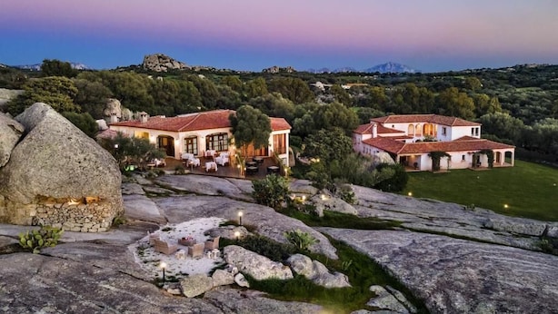 Uma propriedade extensa com vários edifícios, uma lareira de pedra e áreas de estar ao ar livre.