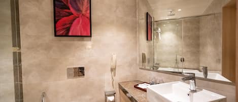 A modern bathroom with a large mirror, two sinks, a shower, and a toilet.