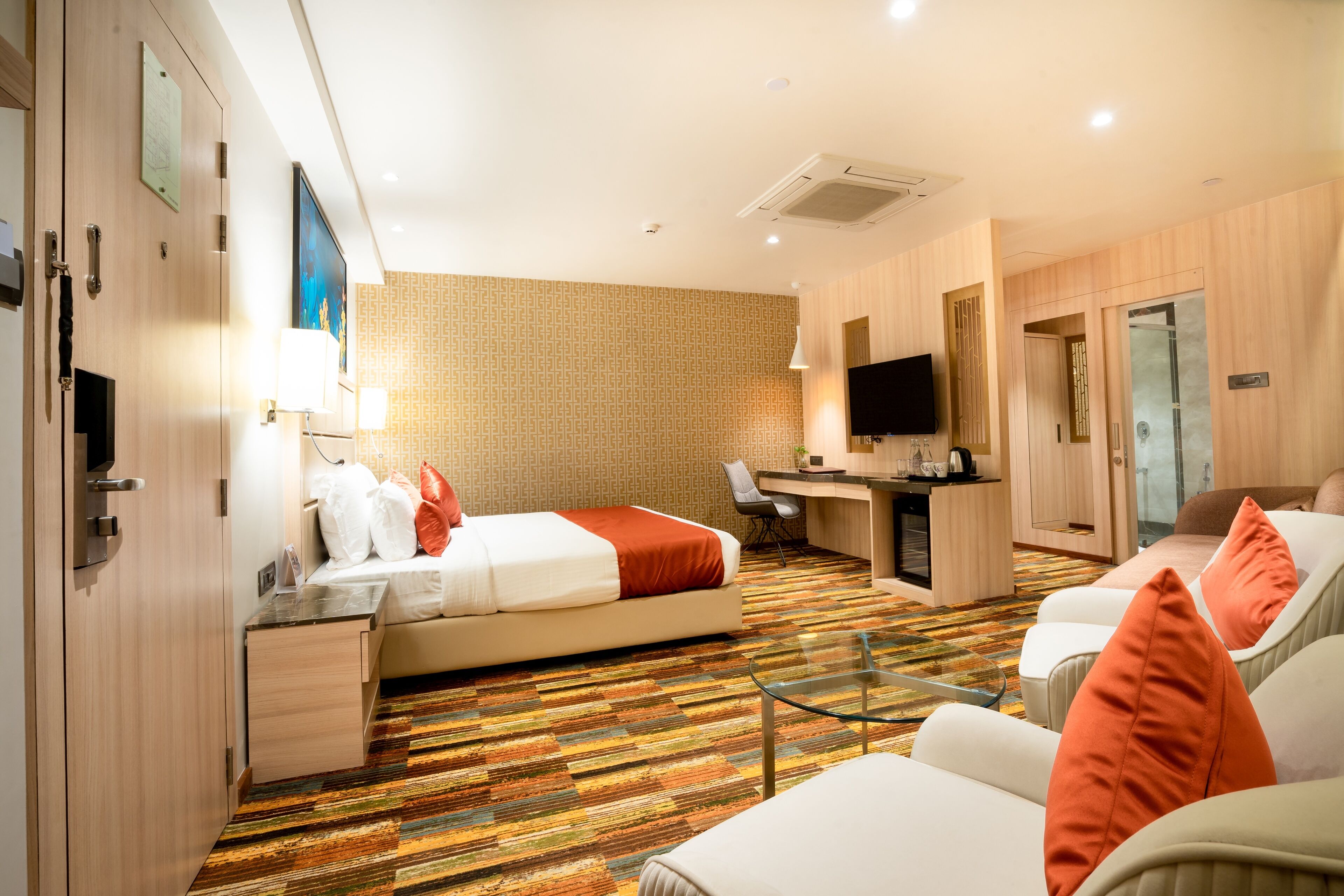 A hotel room with a bed, desk, and seating area.