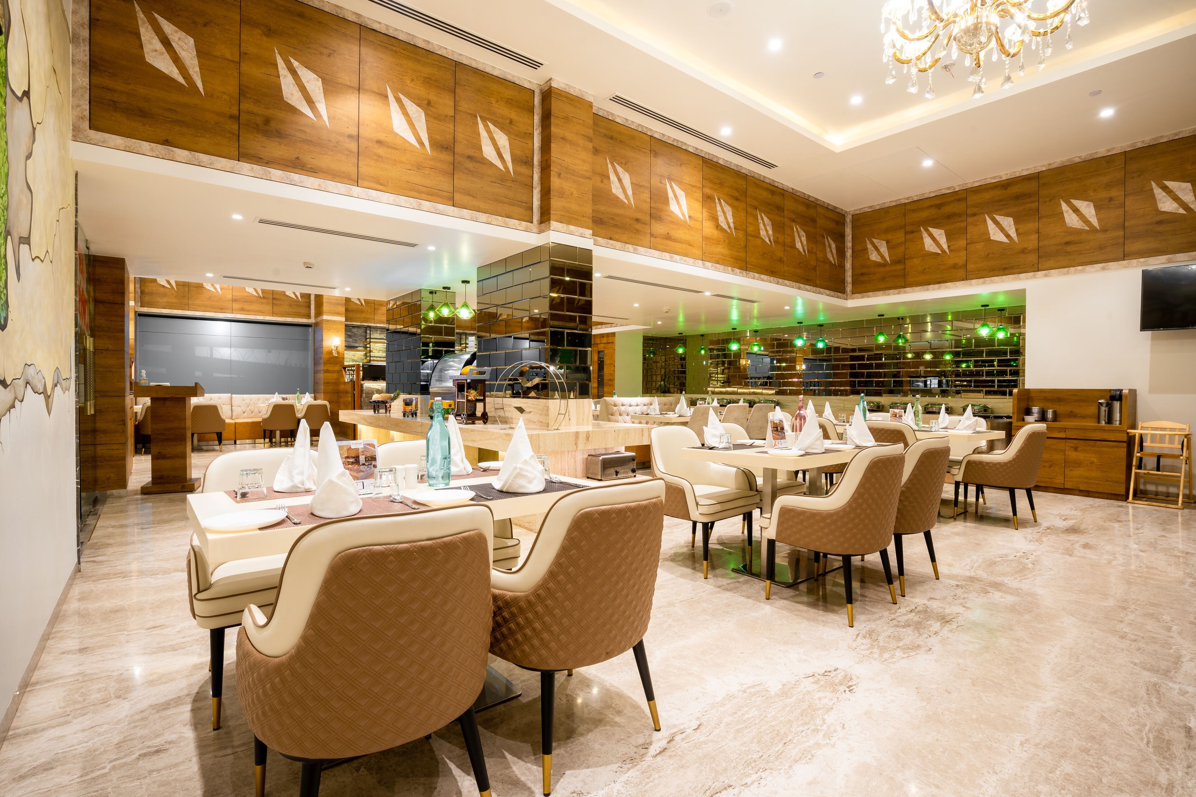 Un comedor amplio con varias mesas y sillas, paneles de madera en las paredes y una lámpara moderna.