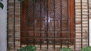 Una puerta de madera con detalles de metalurgia elaborada y un muro de piedra.