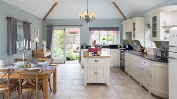 A spacious kitchen with wooden cabinetry, a central island, and a dining area with a table set for four.