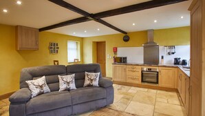 A modern kitchen with a built-in oven, a microwave, and a stainless steel range hood. - Snowdrop Cottage (Knaresborough)