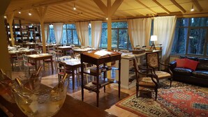 A spacious room with wooden beams, large windows, and a cozy seating area with a patterned rug. - Brolio Agriroom (Gaiole in Chianti)