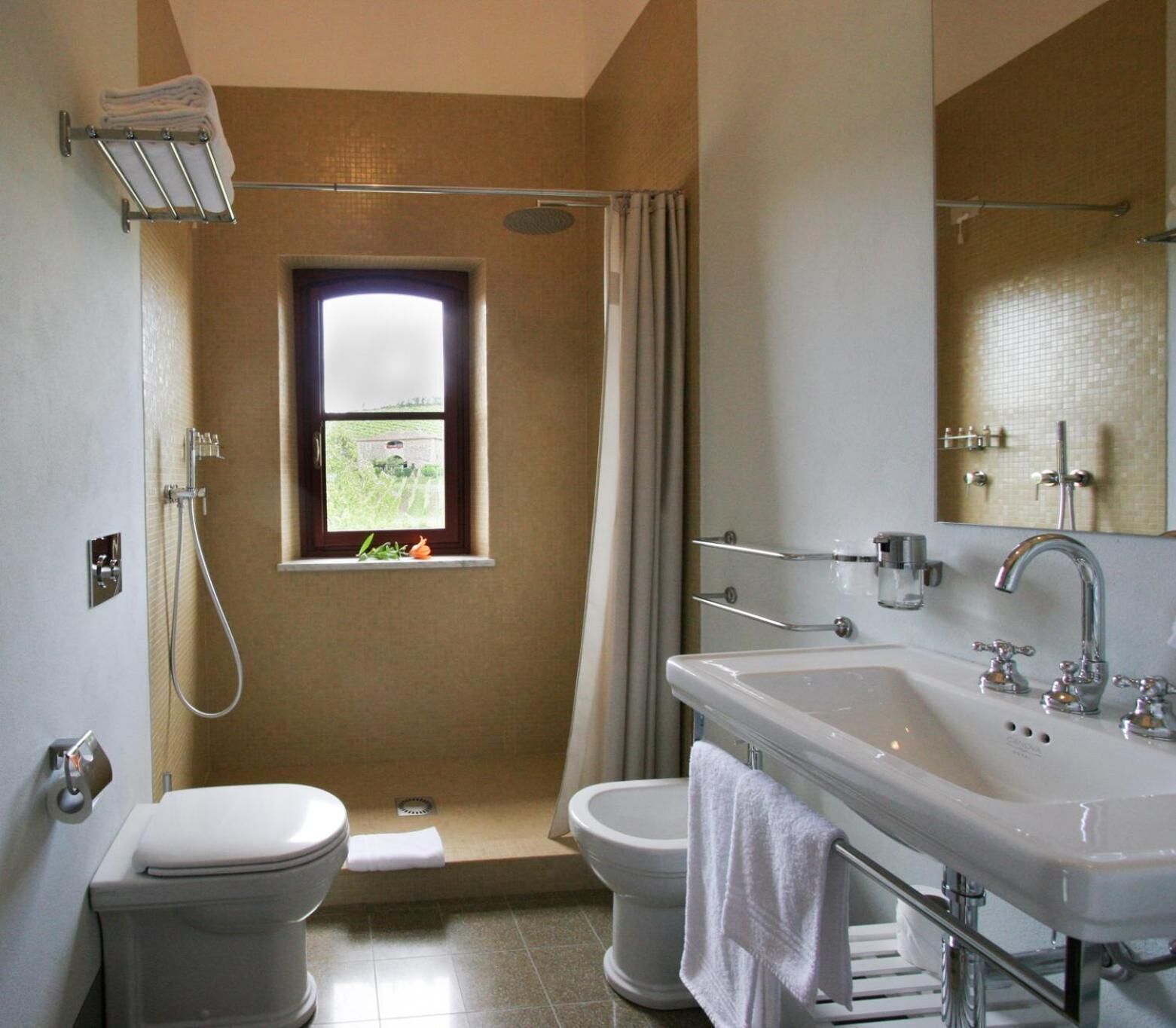 Un baño con ducha, inodoro, bidé y lavamanos.