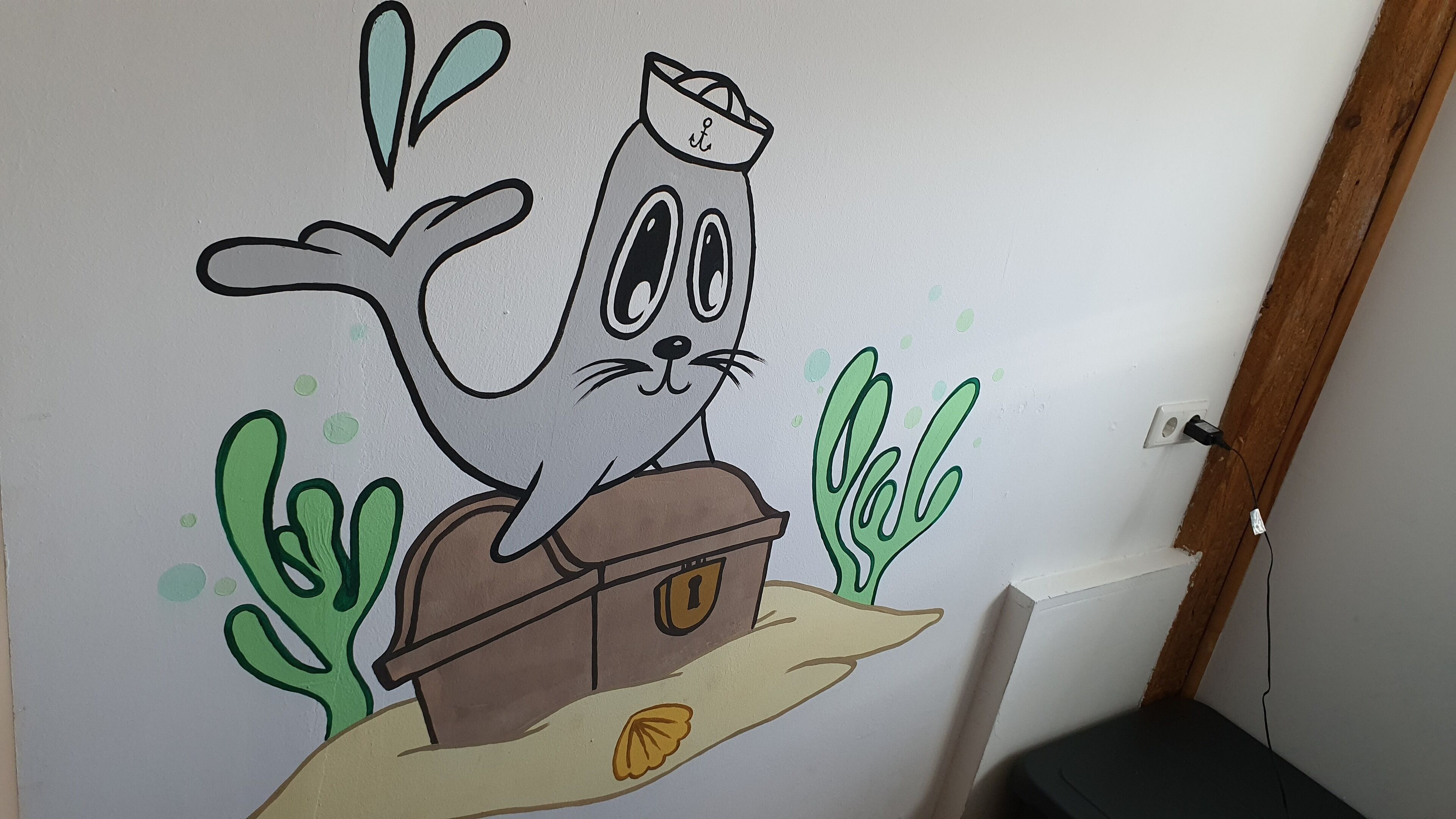 Un chat de dessin animé dans un bateau, peint sur un mur.