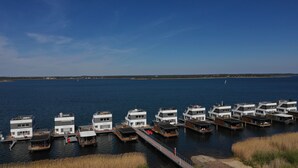 A waterfront property with multiple floating houses docked at a pier, connected by walkways.
