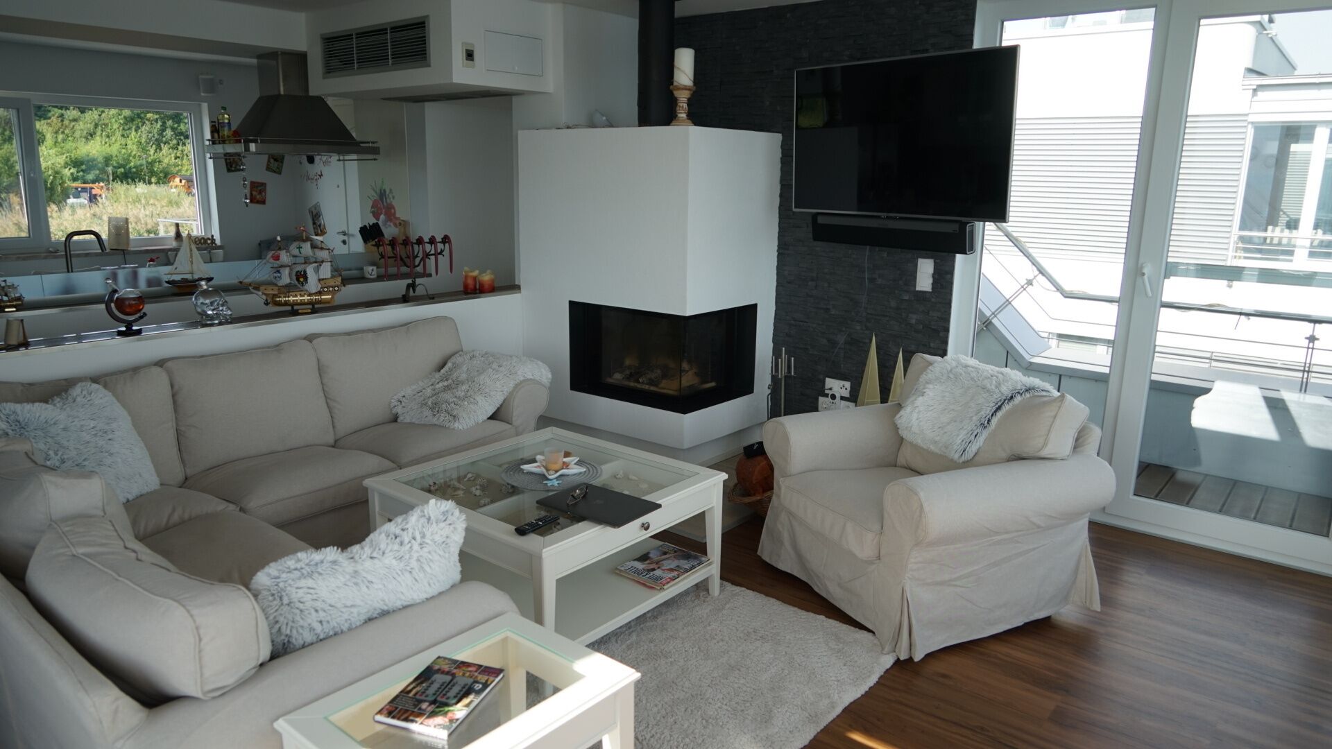 Un salon moderne doté d’une cheminée, d’un téléviseur à écran plat et d’un balcon offrant une vue agréable.