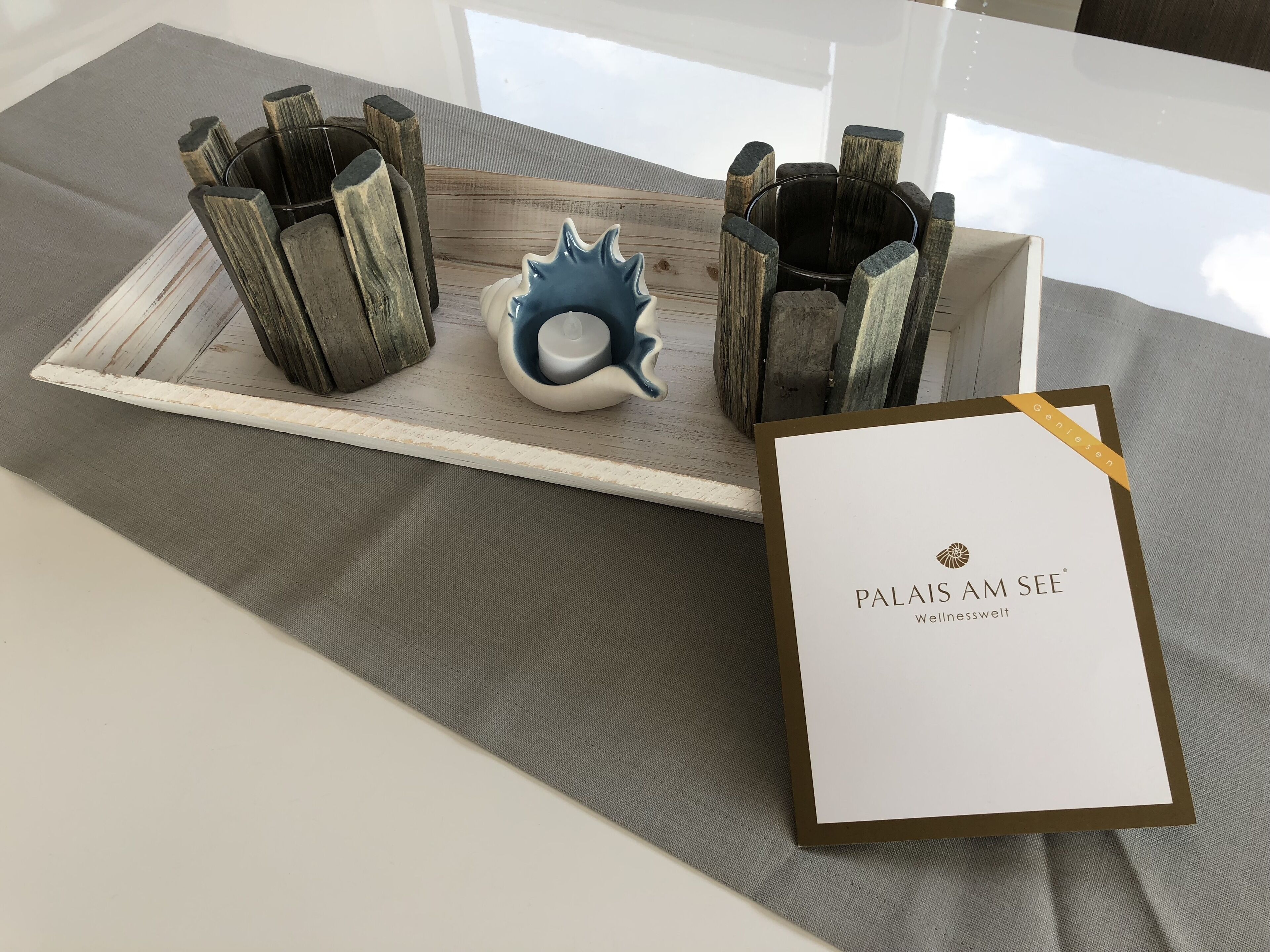Een dienblad met een decoratief object en een kaartje met de tekst 'Palais am See Wellnesswelt'.