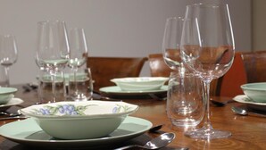 A dining table set with clear glassware, a floral bowl, and matching plates.