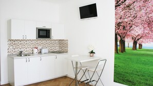 Una cocina moderna con armarios blancos, microondas y salpicadero de azulejos.
