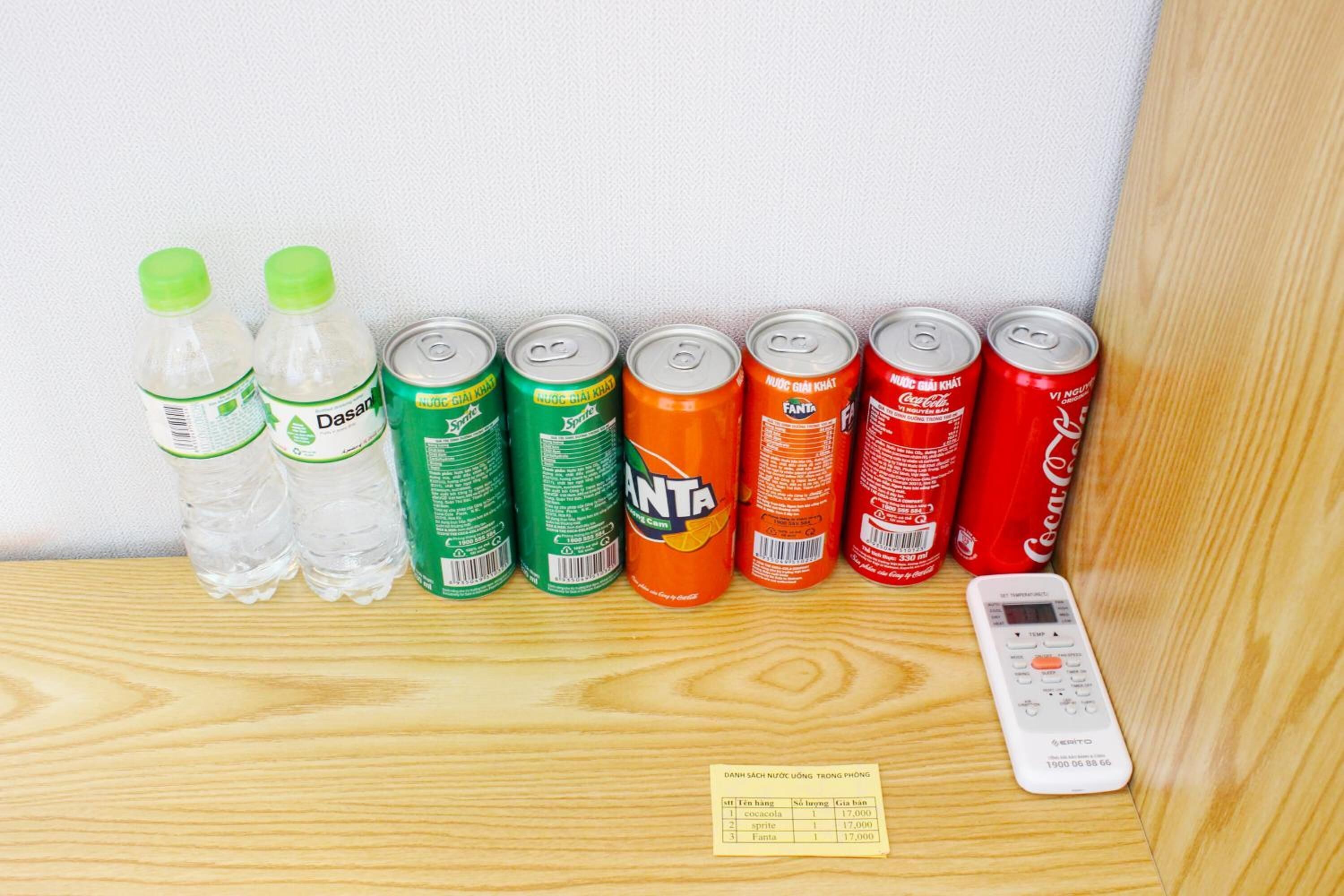 Una estantería con diferentes bebidas y un control remoto.