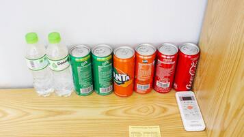Una estantería con diferentes bebidas y un control remoto.