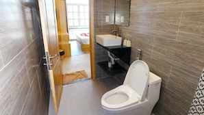 Un baño moderno con inodoro, lavabo y espejo.