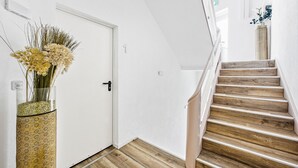 Una escalera con escalones de madera y una puerta blanca.