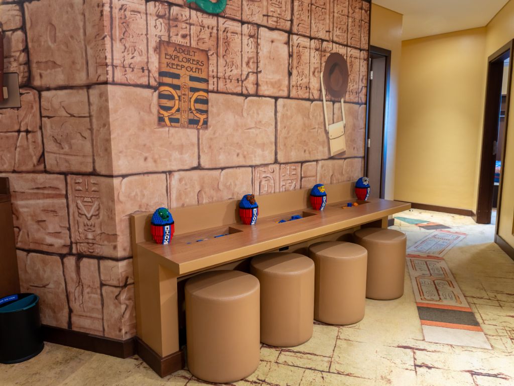 A reception area with a stone wall, a wooden counter, and a trash bin.