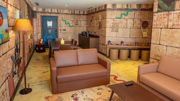 Una habitación con un mural de pared de piedra, un sofá marrón, una mesita y una lámpara.
