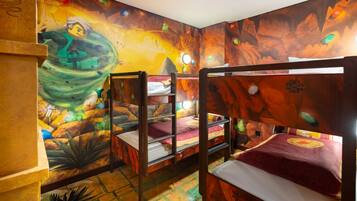 A room with bunk beds, a mural, and a key-shaped floor decoration.