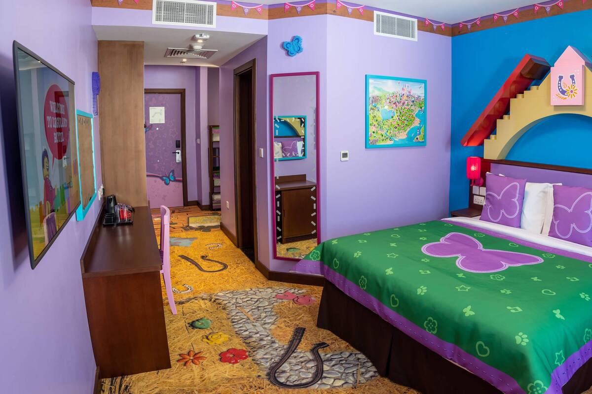 Una habitación con cama, escritorio y silla. Tiene una ventana y una puerta.