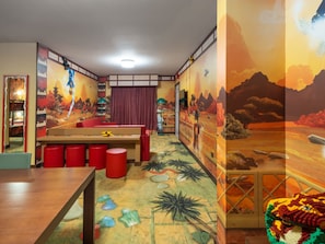 A room with a mural, a bed, a desk, and red stools. - LEGOLAND Hotel Dubai (Dubai)