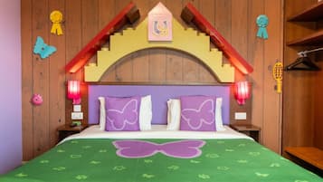 A room with a bed, wooden headboard, decorative pillows, and wall-mounted lights.
