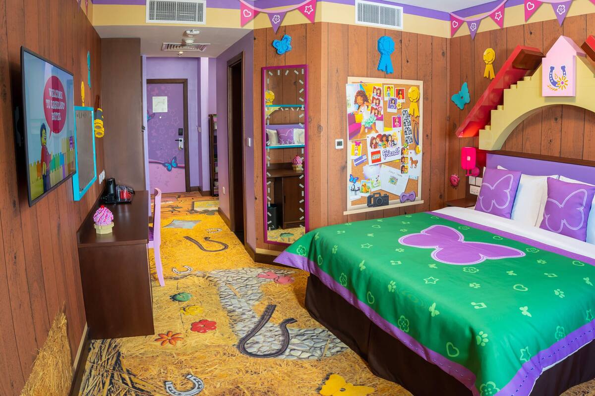 Una habitación infantil con una cama, un escritorio y un tablón de anuncios.