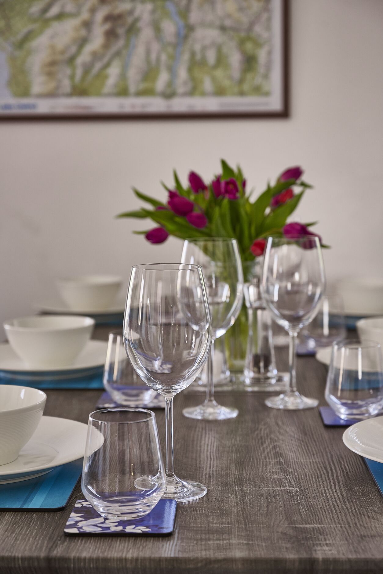 A dining table set with multiple wine glasses, bowls, and plates.