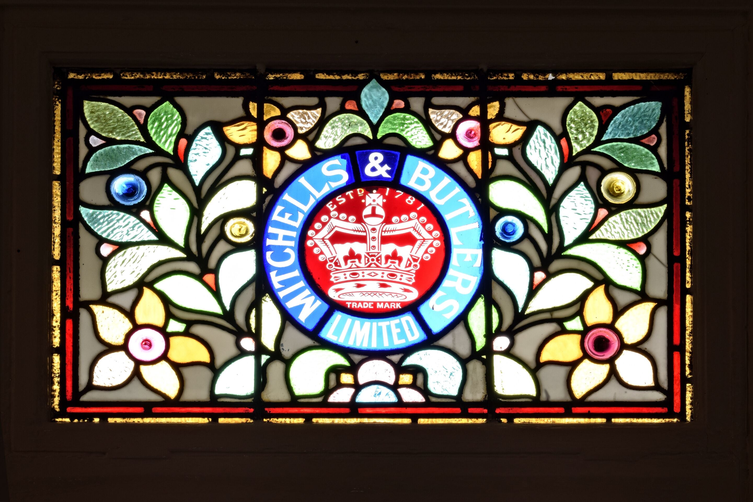 A stained glass window with the text "Shells & Butlers Limited" and a crown emblem.