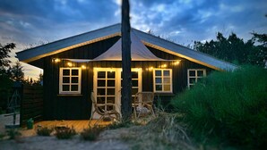 Une cabane en bois avec une véranda, une chaise et une table.