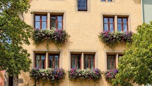 A two-story building with a sign reading 'herrnsschlöschen hotel & restaurant - cafe - spa park.' - Hotel Herrnschloesschen (Rothenburg ob der Tauber)