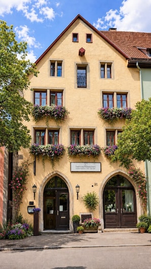A two-story building with a sign reading 'herrnsschlöschen hotel & restaurant - cafe - spa park.' - Hotel Herrnschloesschen (Rothenburg ob der Tauber)