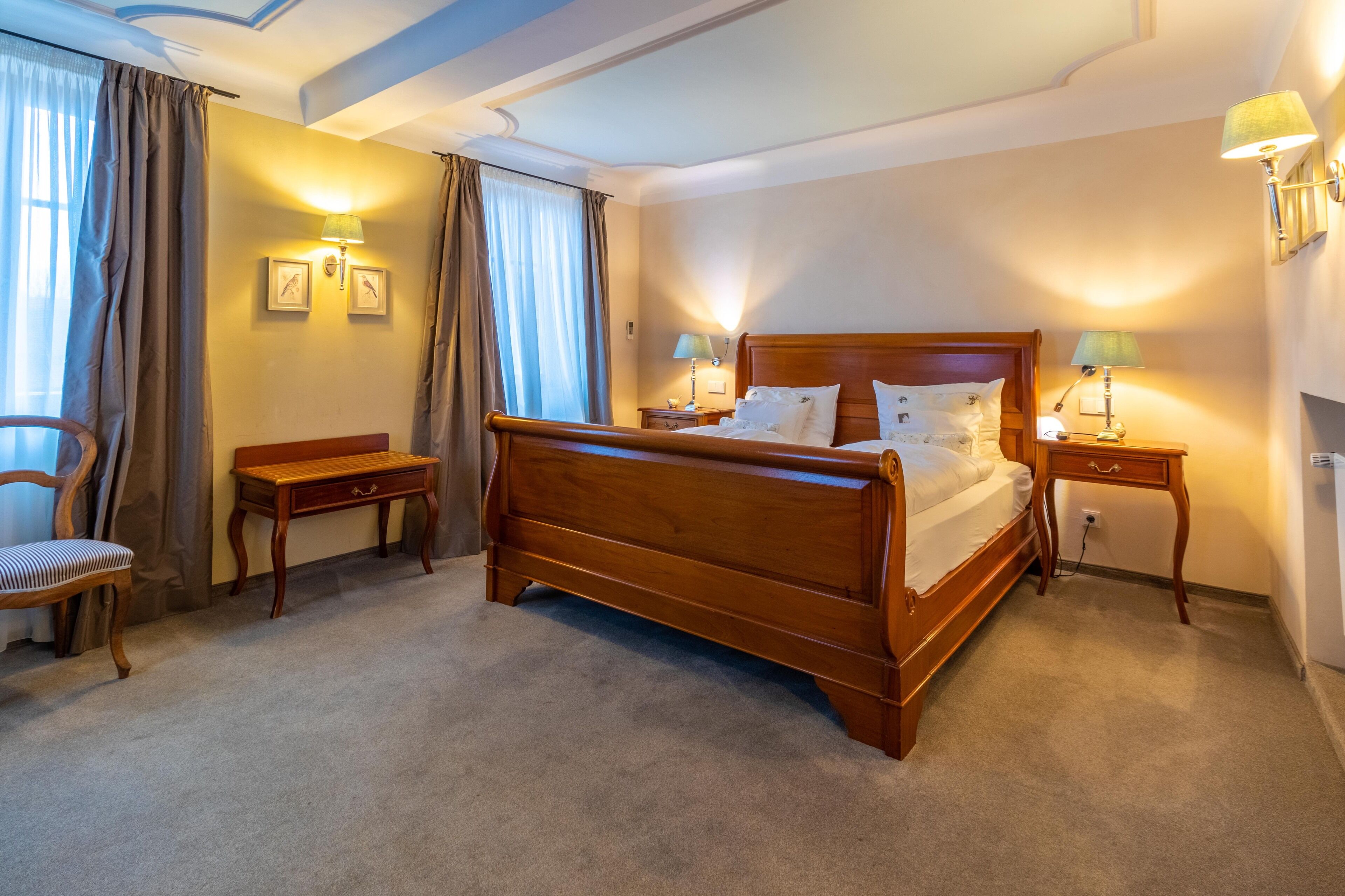Ein Hotelzimmer mit einem hölzernen Bett, zwei Nachttischen, einem Sessel und einer Lampe.