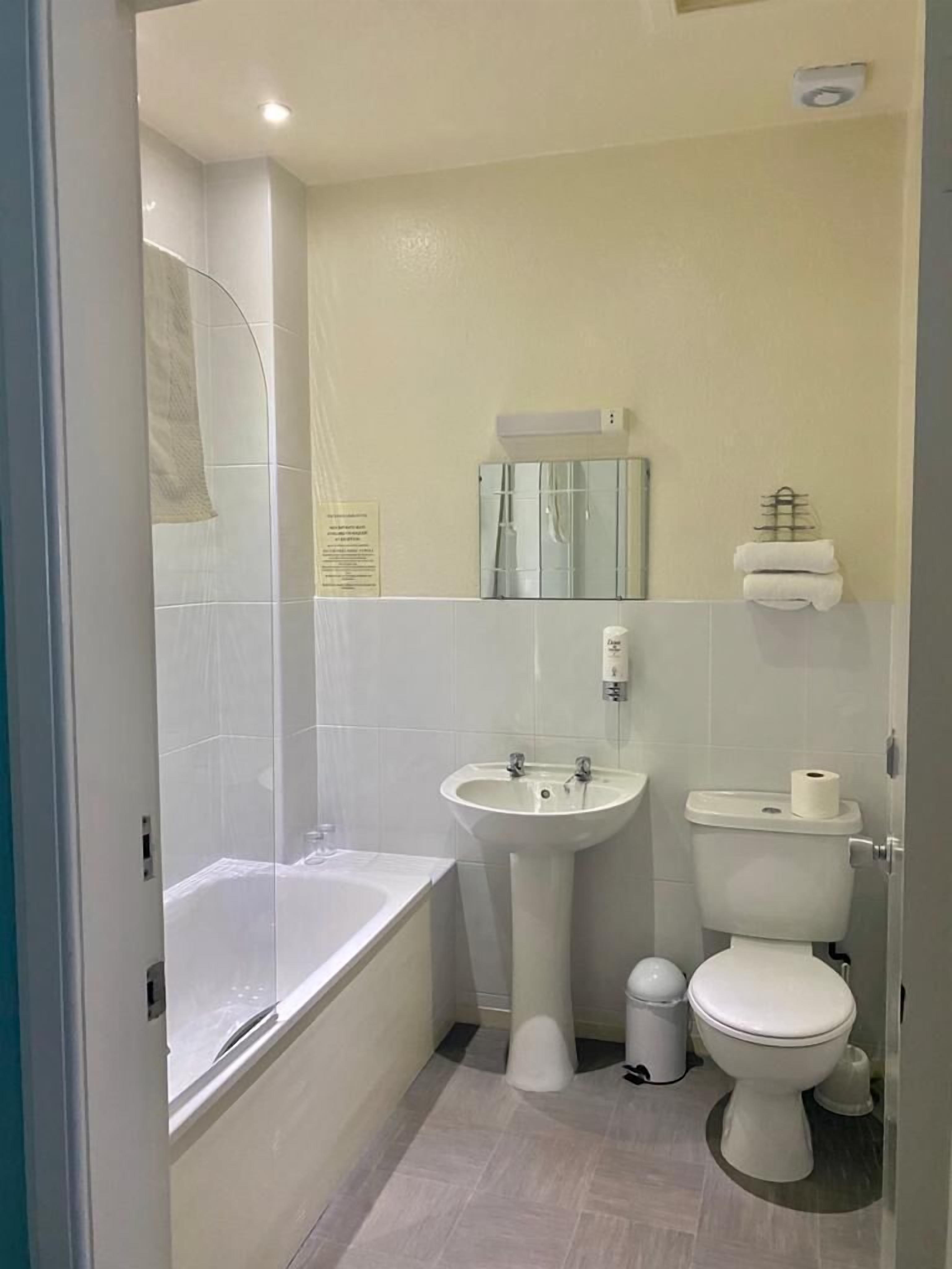 A modern bathroom with a bathtub, sink, and toilet.