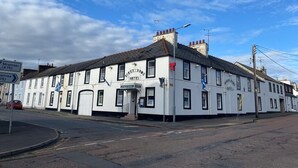 A white building with a sign reading "Stranraer (A75)". - The Kings Arms Hotel (Castle Douglas)