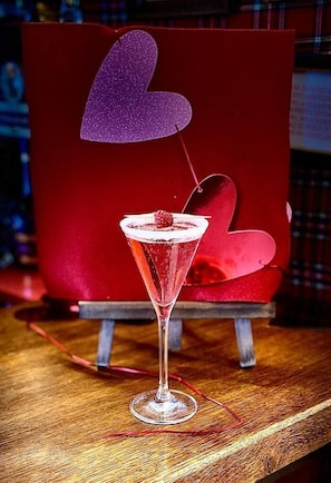 Cocktail-lasi, jossa on sydämenmuotoinen koriste, puupöydällä.