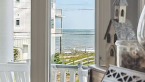 A room with a view of the sea, a small house model, and a piano. - Private Pool, Ocean View, Beach Access Across Street - Castle By The Sea (Folly Beach)