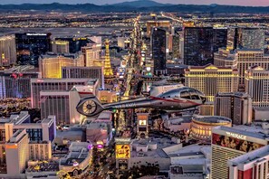 Un hélicoptère survolant une ville, avec en arrière-plan des bâtiments emblématiques tels que le Cosmopolitan et le Mirage.