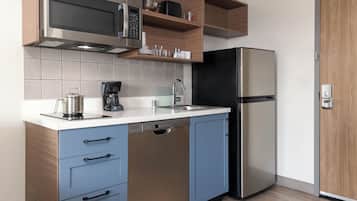 A modern kitchen with stainless steel appliances, wooden shelves, and a dishwasher.