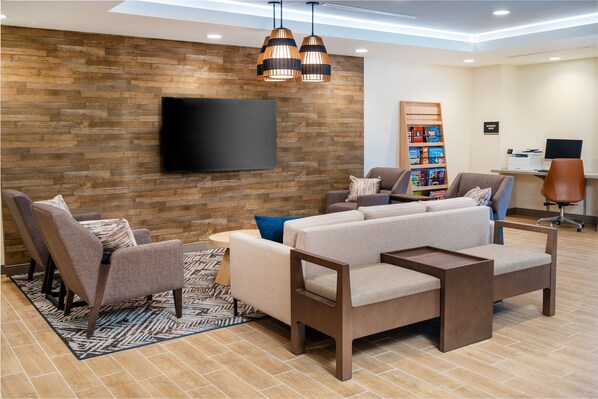 Uma sala de estar moderna com televisão de tela plana, parede de madeira e mobiliário contemporâneo.