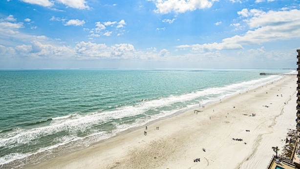 A beach with a clear view of the ocean and a pier in the distance. - Water's Edge 1511 - Two Bedroom, Two Bathroom, Oceanfront Condo (Garden City Beach)