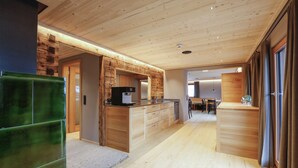 Une cuisine moderne avec des meubles en bois, une cuisinière encastrée et un coin repas comprenant une table et des chaises.