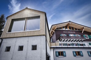 Ein Gebäude mit modernem Design, mit einem großen Fenster und einem Balkon mit Holzgeländern.