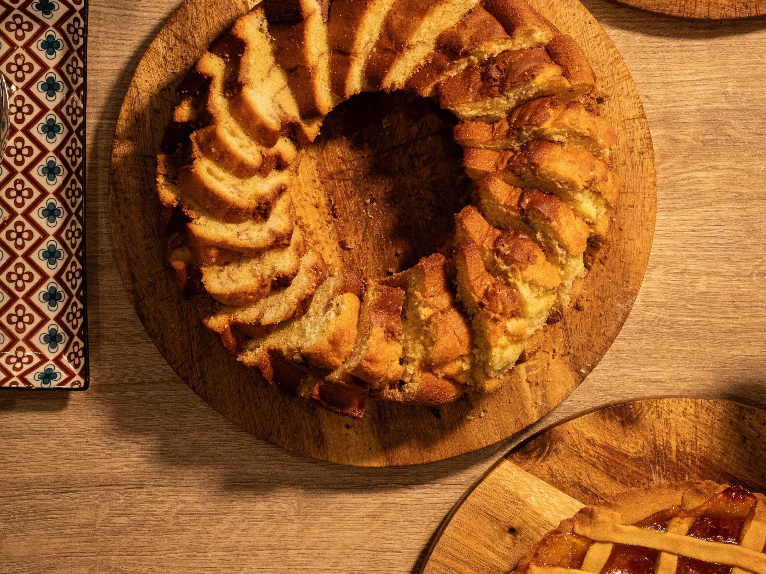 Ein runder Kuchen mit einer Vertiefung in der Mitte, auf einem Holzbrett platziert.