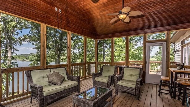A covered porch with wicker furniture, a ceiling fan, and a view of a lake. - Come have fun in the sun on the Tennessee River with a private dock (Loudon)