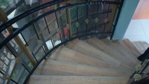 A spiral staircase with wooden steps and metal railings.