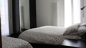 Un dormitorio con cama, armario y radiador.