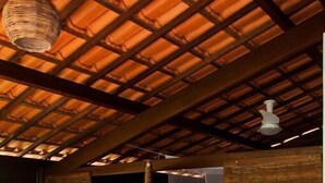 A room with a wooden ceiling, a hammock, a bed with a white canopy, and a wooden chair. - Pousada Albergue da Jangada (São Miguel do Gostoso)