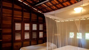 A room with two beds, wooden walls, and a canopy bed. - Pousada Albergue da Jangada (São Miguel do Gostoso)