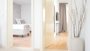 A hotel room with a bed, a television, a curtain, and a vase with branches. - Apartments Stipisic (Hvar)