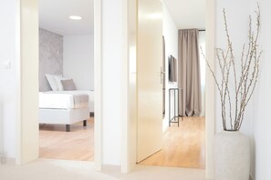 A hotel room with a bed, a television, a curtain, and a vase with branches. - Apartments Stipisic (Hvar)